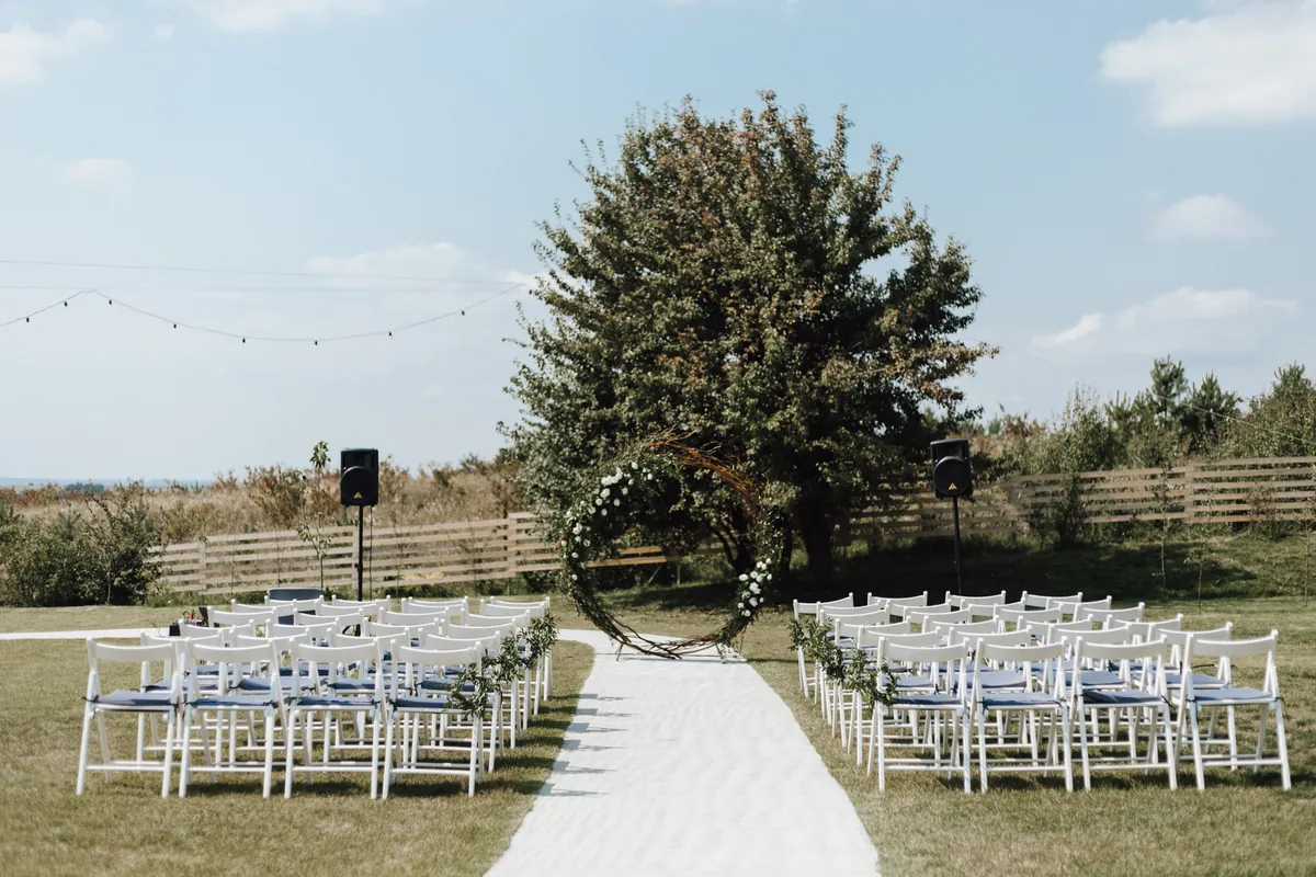 Rows of white chairs arranged for an outdoor wedding ceremony.