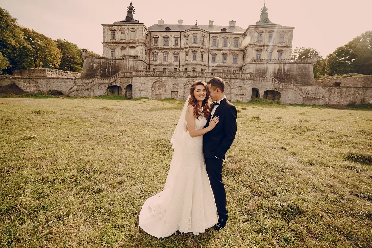 A couple embracing in the grounds of a grand country house wedding venue.